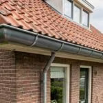 Nieuwe zinken dakgoot aan een woning met een pannendak