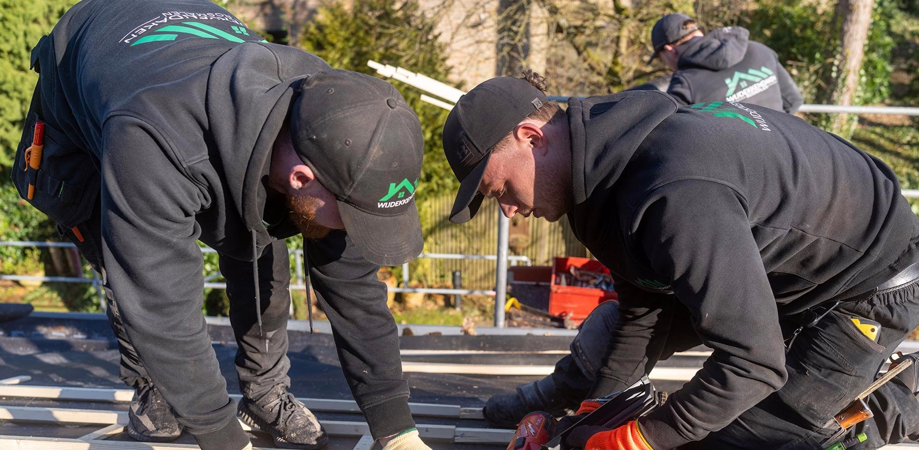 Dakdekkers van WijDekkenDaken werken samen op een dak